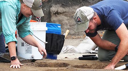 Students digging on a archaeological dig.